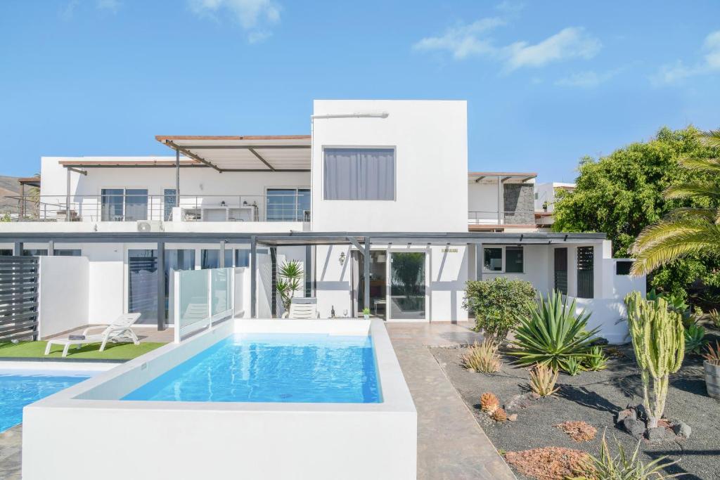 ein weißes Haus mit einem Swimmingpool davor in der Unterkunft Casa amanecer 1 in Mácher