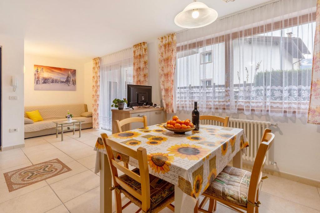 a dining room and living room with a table and chairs at Night and day 3 in Predazzo