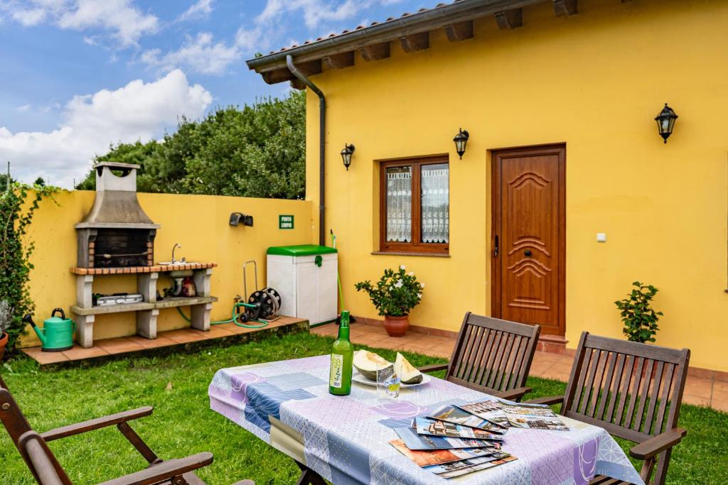 eine Terrasse mit einem Tisch und einem Grill im Hof in der Unterkunft Apto Rosa - Casa el gaitero in Susacasa