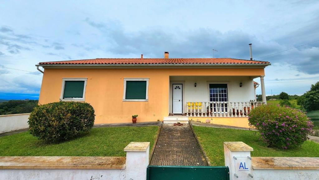ein kleines gelbes Haus mit einem Gehweg davor in der Unterkunft Casa Avó Judite - Castelo Óbidos in Óbidos