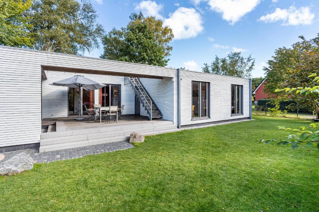 a small white house with a patio and grass at Haus Börnsteen in Zingst