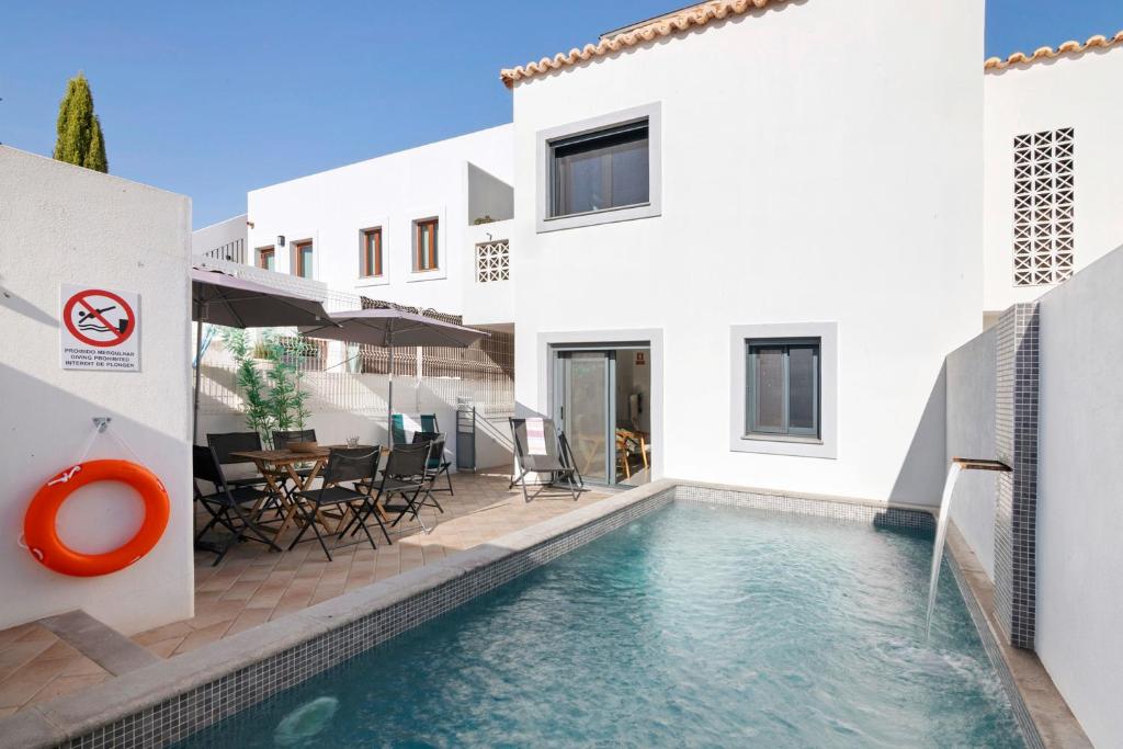 a villa with a swimming pool in front of a house at Villa - Canas Da Ria - Piscine in Santa Luzia
