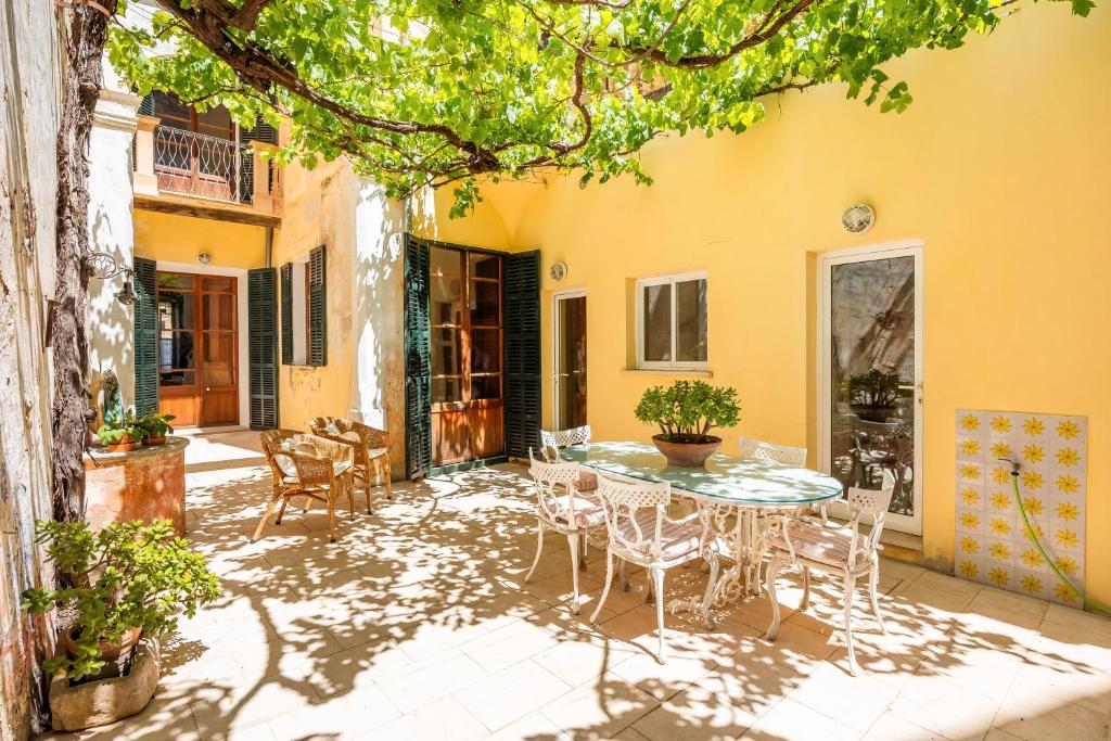Un patio con una mesa y sillas frente a un edificio. en Cas Sitger, en Felanitx