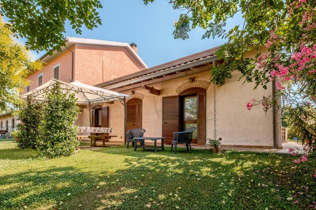 a house with a table and a bench in the yard at Agriturismo Col Moschin in Grosseto