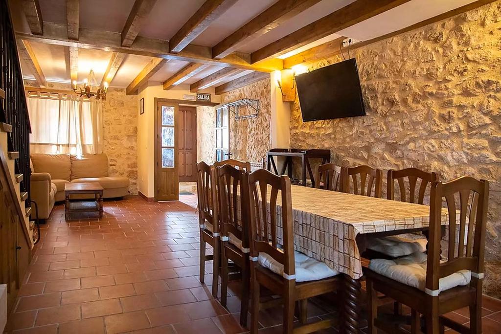 a dining room with a table and chairs and a television at La Marcela in Aldea de San Esteban