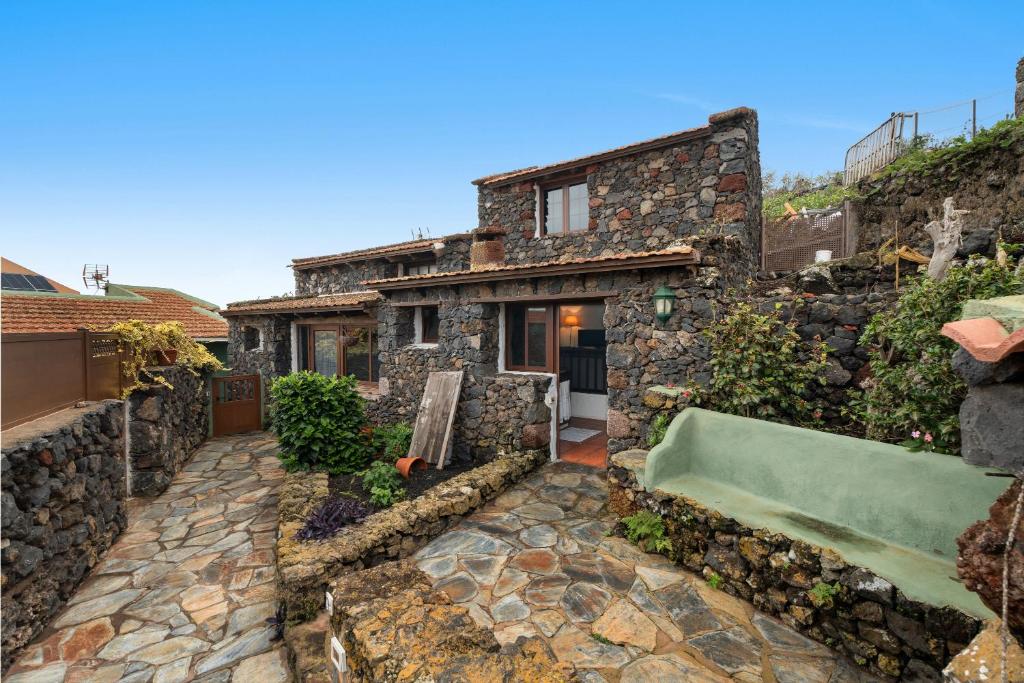 a stone house with a bathtub in a yard at Tesbabo Rural - Camelia in Mocanal