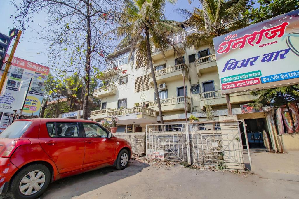 a red car parked in front of a building at SPOT ON Indirasagar Executive in Kolhapur