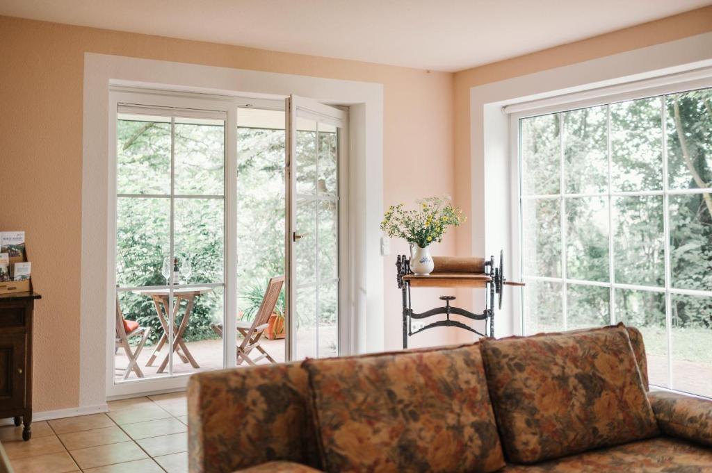 ナウムブルクにあるLandhaus Elbenbergのソファと大きな窓のあるリビングルーム
