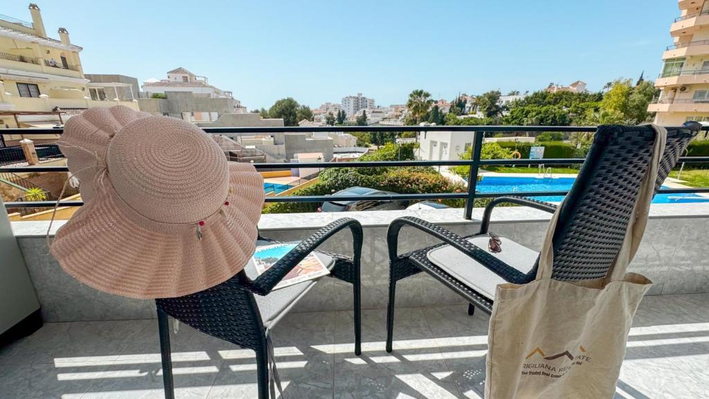 a woman wearing a straw hat sitting on a balcony at Hawaii 1st floor Burriana, Nerja in Nerja