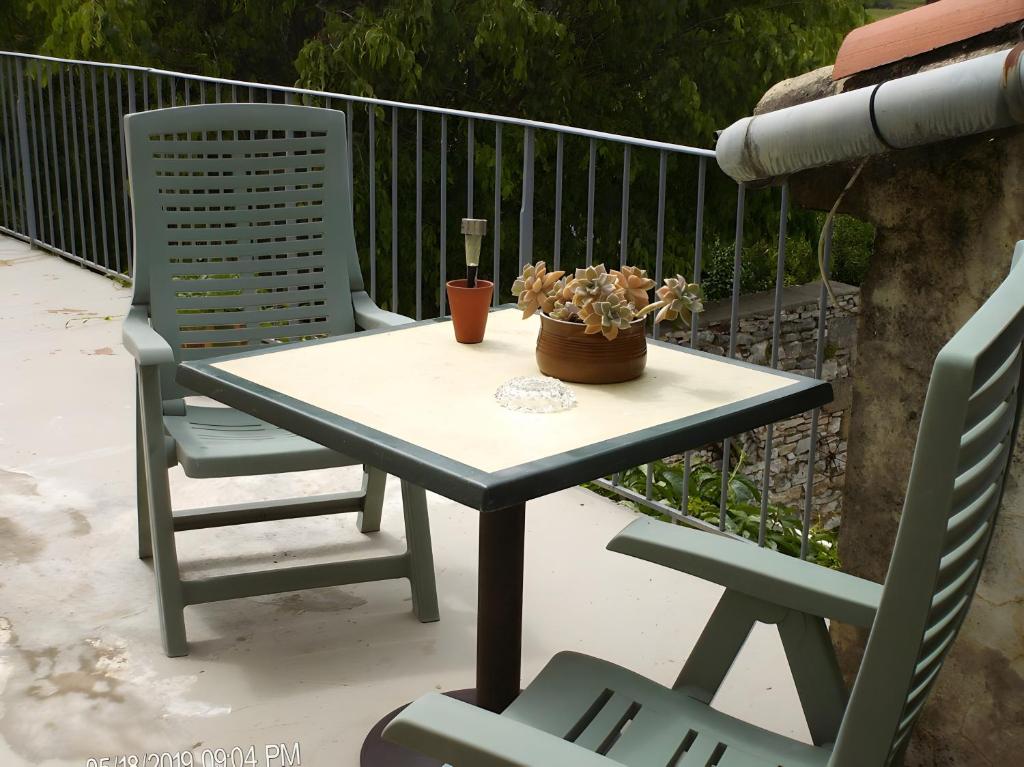 a table with two chairs and a potted plant on it at Chambres d'hote chez Françoise in Salinelles