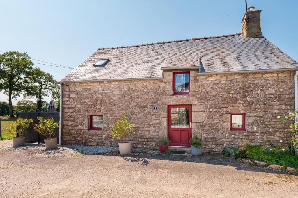 ein Steinhaus mit einer roten Tür in der Unterkunft Gîte à la ferme de Questembert in Questembert