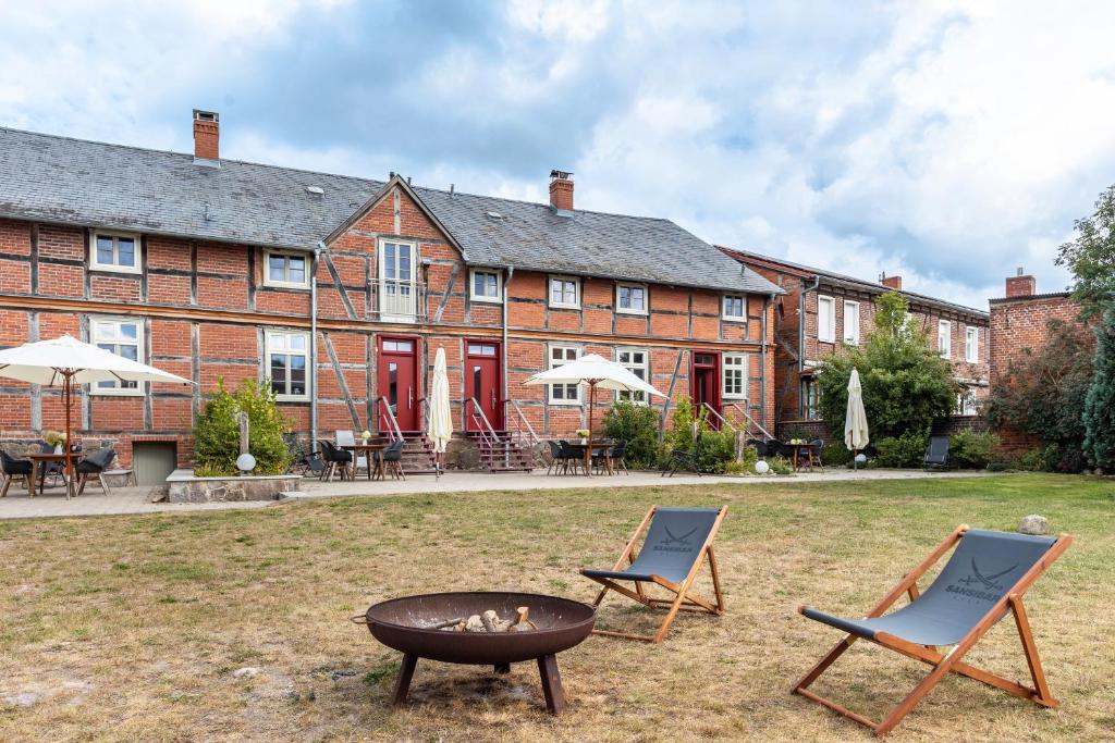a house with two chairs and a fire pit in the yard at Hof Rosenstein in Helle