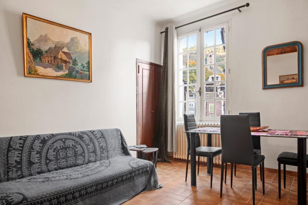 un salon avec un canapé et une table avec des chaises dans l'établissement Appartement 2eme étage, à Castellane