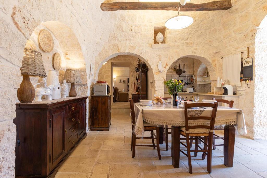 une cuisine et une salle à manger avec une table et des chaises dans l'établissement Trullo Nurillo, à Alberobello