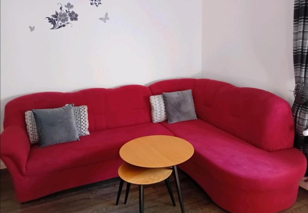 a red couch in a living room with a table at Wohnung am Bahnhof Schwerte in Schwerte