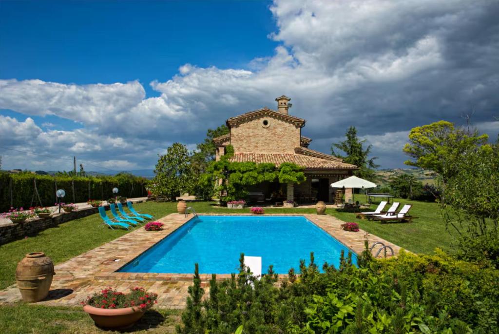 a house with a swimming pool in a yard at Italian Experience-Villa Incanto in Potenza Picena