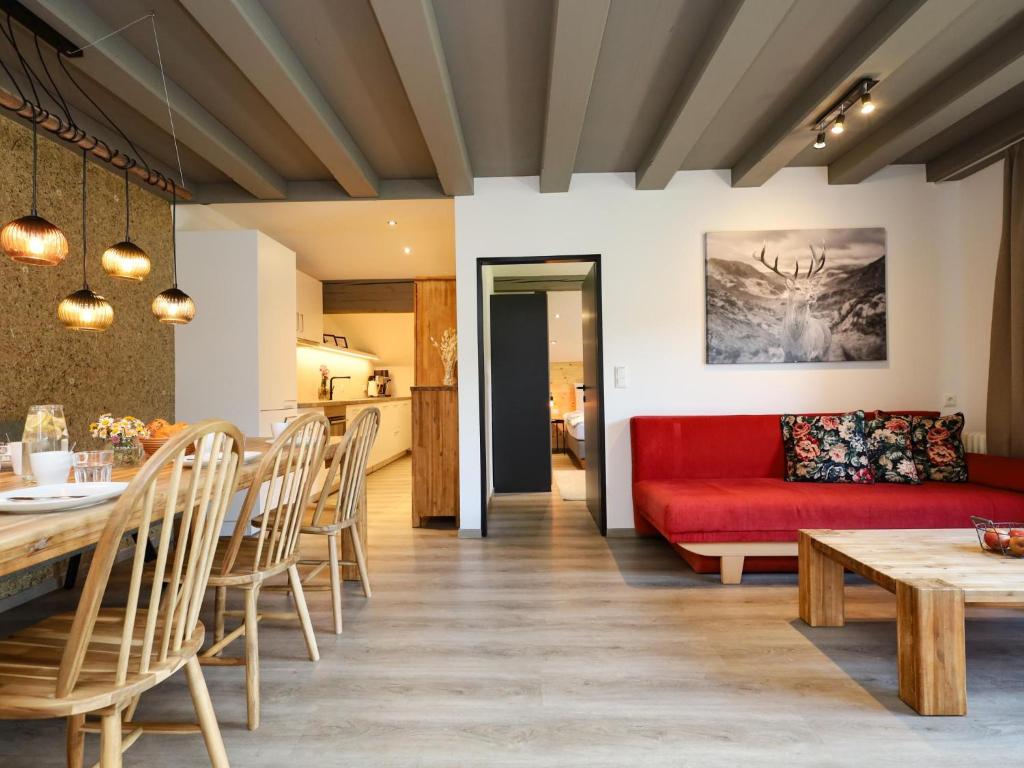 un salon avec un canapé rouge et une table dans l'établissement Tirola Platzl, à Hopfgarten im Brixental