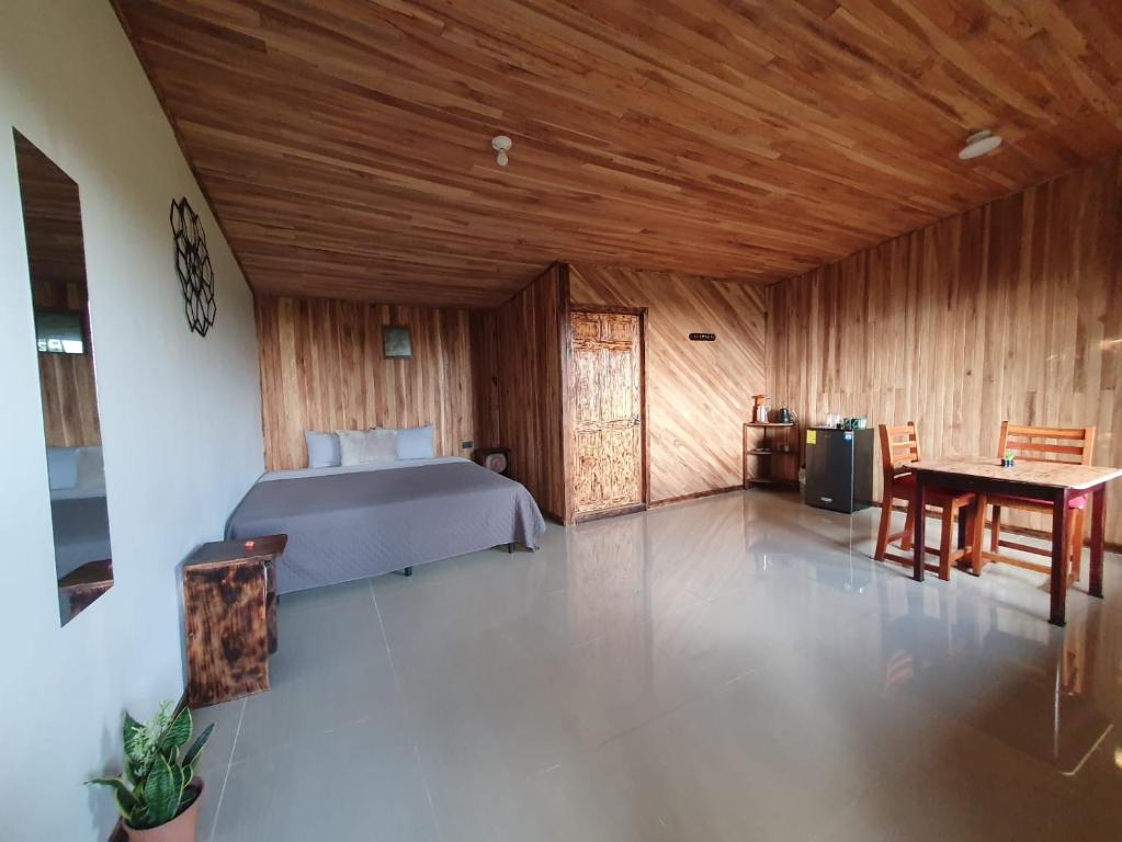 a bedroom with a bed and a table in a room at El Chagüite monteverde #2 in Monteverde Costa Rica