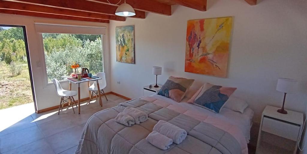 - une chambre avec un grand lit dans une pièce dotée de fenêtres dans l'établissement La Casa de los Cuadros, à Lago Puelo