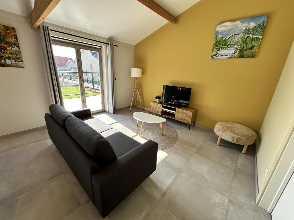 Una sala de estar con un sofá y un televisor en Westhinder II H18, en Koksijde