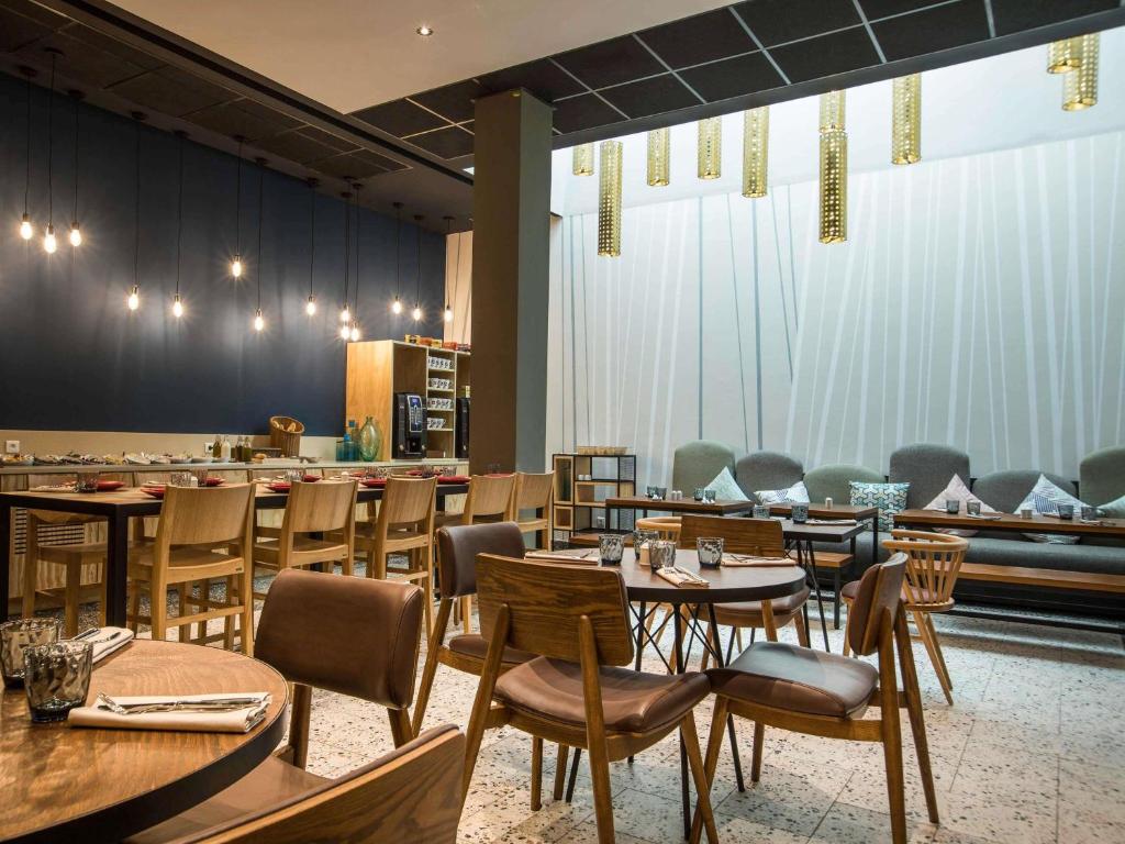 a restaurant with tables and chairs and a bar at Ibis Abdelmoumen Casa Centre in Casablanca
