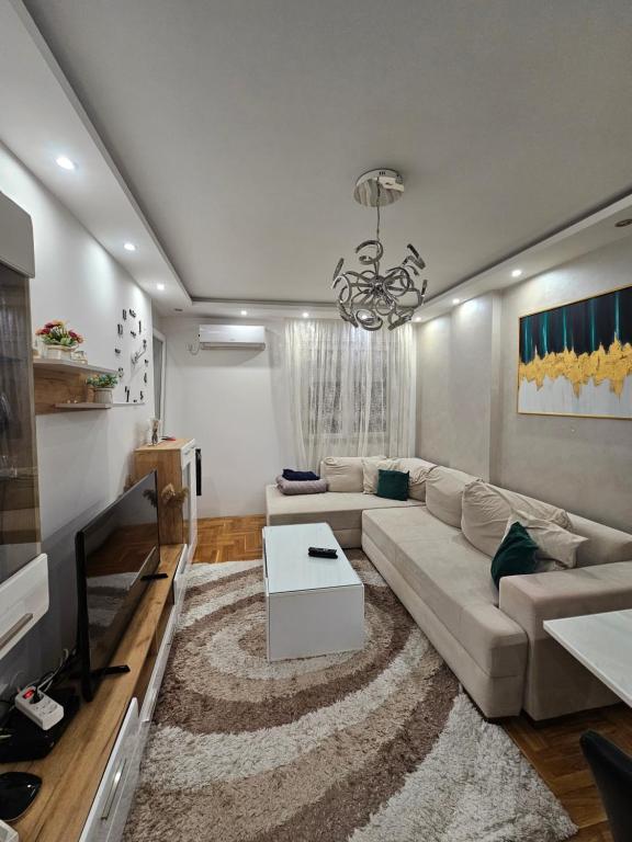 a living room with a couch and a table at Apartman ANIR in Novi Sad
