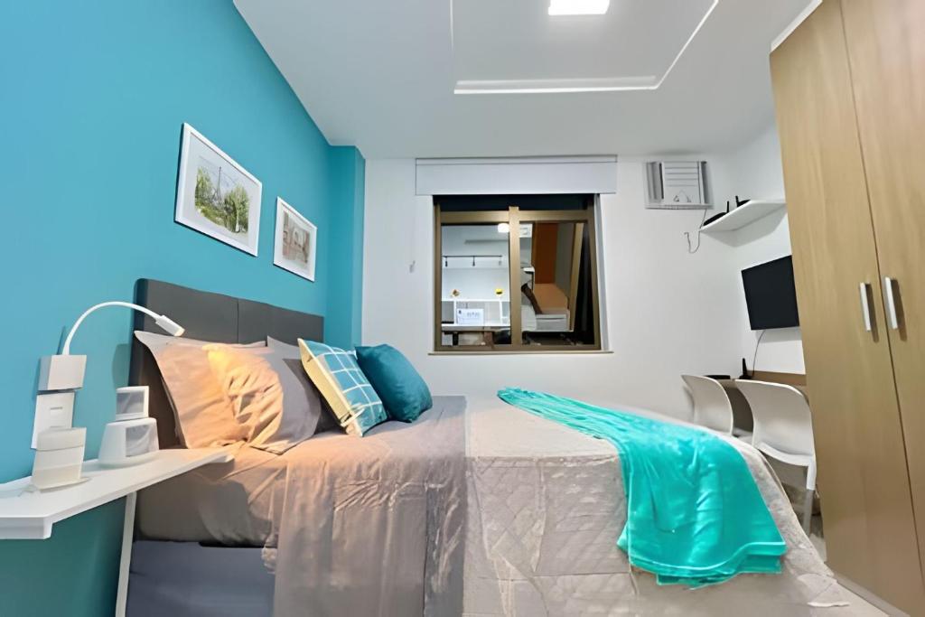 a bedroom with a bed with a blue wall at Moderno com piscina e perto da praia in Rio de Janeiro