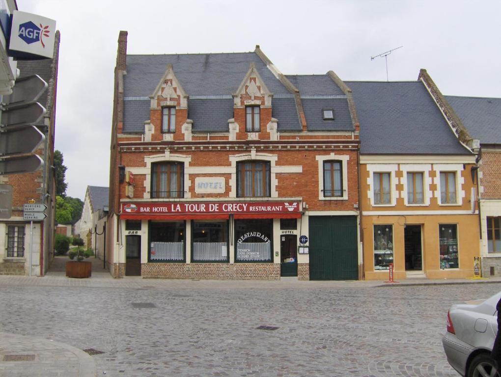 an old brick building on a city street at La Tour de Crecy in Crécy-sur-Serre