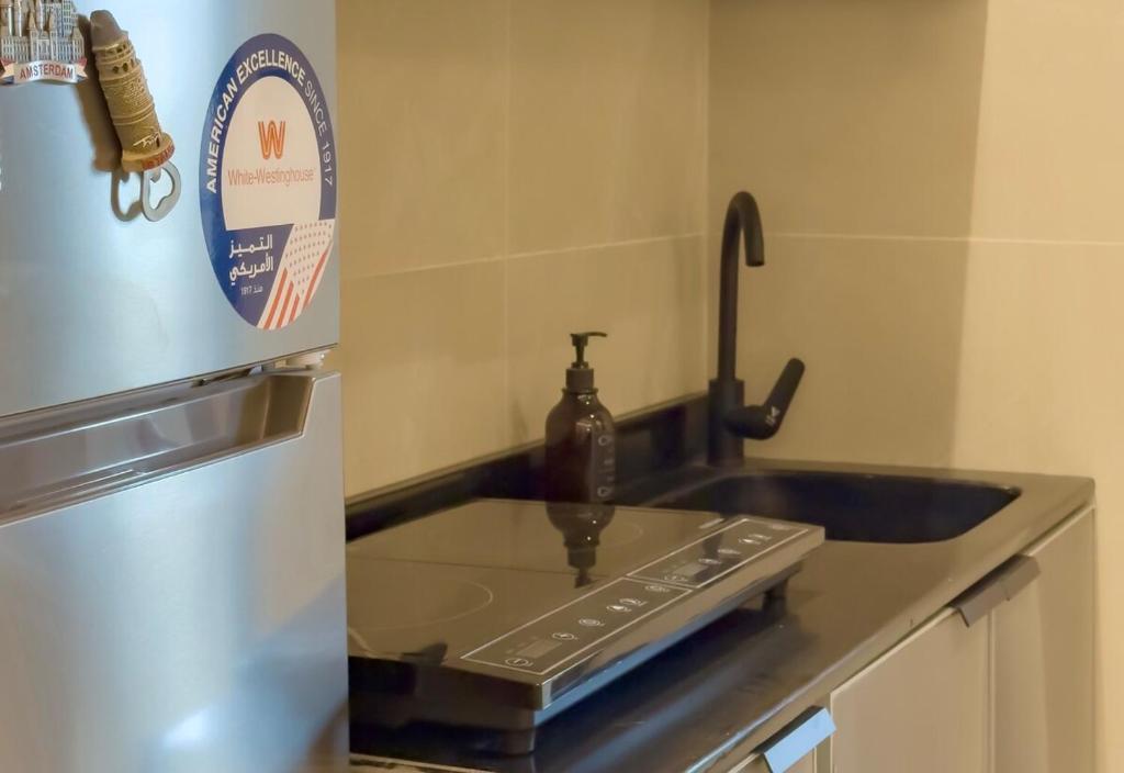 a kitchen with a sink and a refrigerator at Spacious apartment next to the financial towers B10 in Quai