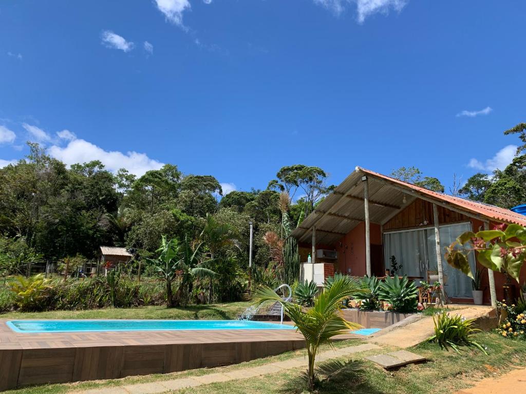 a house with a swimming pool in front of it at Chácara Recanto dos Fortes in Casimiro de Abreu