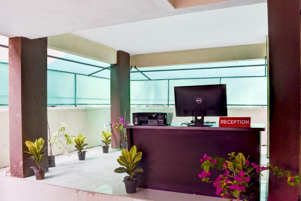 an office with a desk with a computer and plants at Hotel O Sai Residency in Wagholi