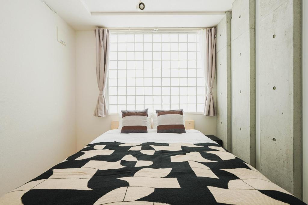 ein Schlafzimmer mit einem Bett mit einem großen Fenster in der Unterkunft Ｂｒａｎｃｈｅ住吉ＥＡＳＴ in Fukuoka