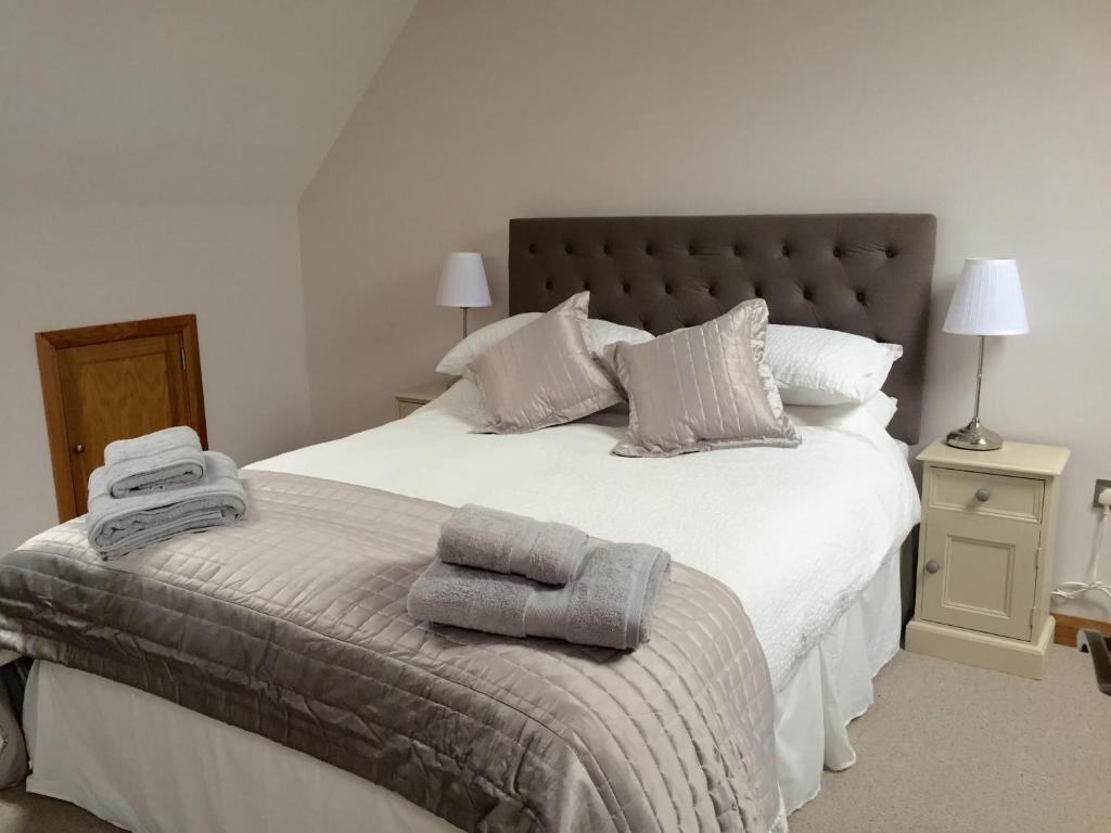 um quarto com uma grande cama branca com toalhas em The Barn - Nr Bromyard em Bromyard