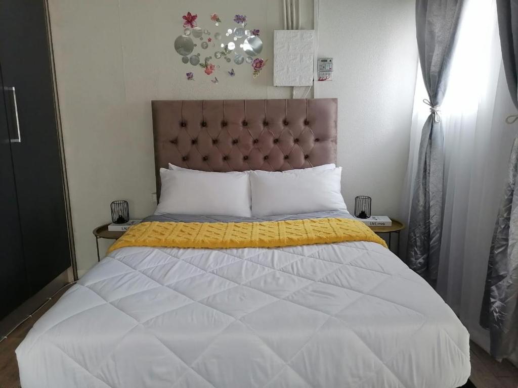 a bedroom with a large bed with a yellow blanket at The Converted Space in Welkom