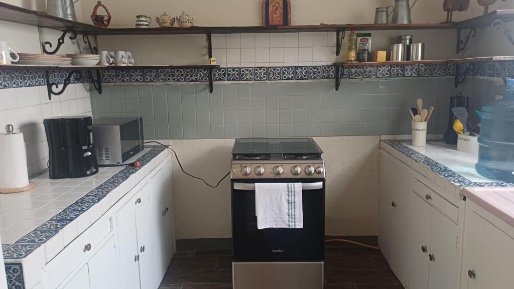 een keuken met witte kasten en een fornuis. bij Hotel villa 15 in Las Victorias