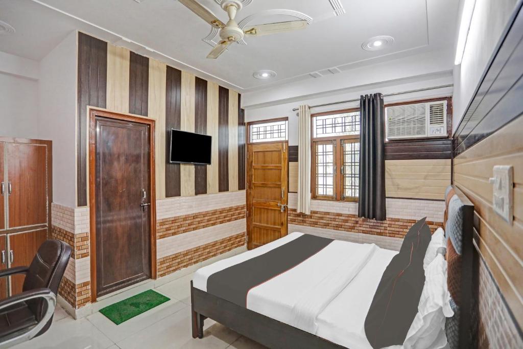 Un dormitorio con una cama y un televisor de pantalla plana. en Hotel O Vrishti Hotels by Ananda, en Sūrajpur