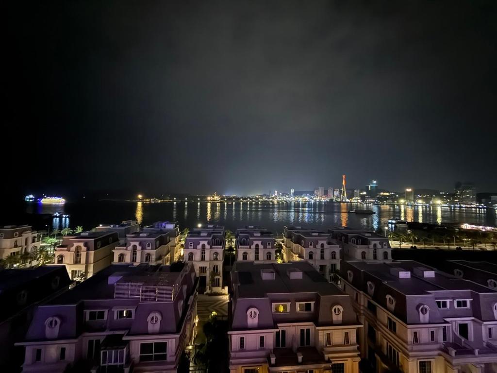 een uitzicht op een stad 's nachts met paarse huizen bij Sky Homestay 1 in Ha Long