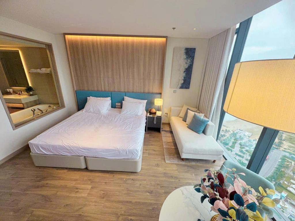 下龙湾À Là cart studio apartment with bay view and water music的卧室里有一张床、一张沙发和一面镜子