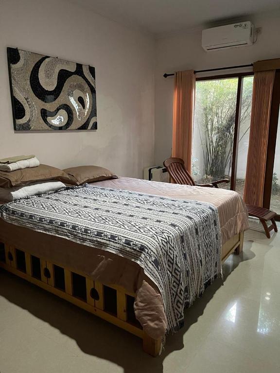 a bedroom with a bed with a blanket on it at Karmani Villa Managed by Alyssa Villa Management in Ujung