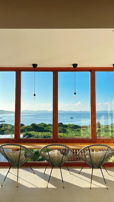 two chairs sitting in front of a large window at Hummocks in Sesoko