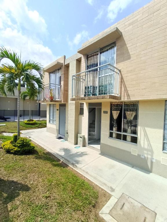 a building with a palm tree in front of it at Casa ubicada en zona campestre de Ibagué in Ibagué