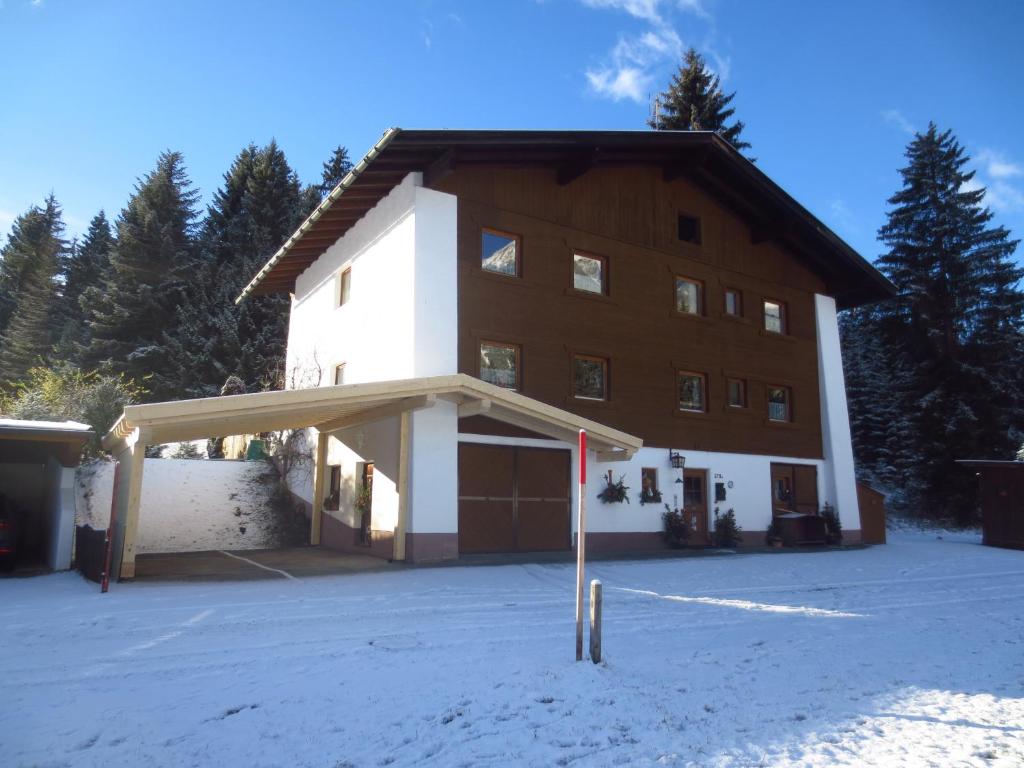 ein großes braunes und weißes Gebäude im Schnee in der Unterkunft Landhaus Genoveva in Leutasch