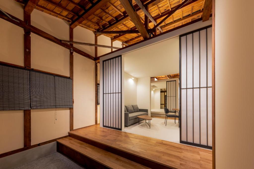 ein Zimmer mit Glasschiebetüren und ein Wohnzimmer in der Unterkunft Miharaya Setoda in Onomichi
