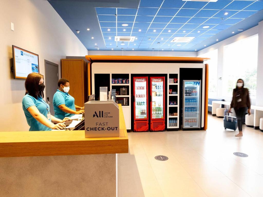 een winkel met mensen die rond een kassa staan bij ibis budget Leme SP in Leme