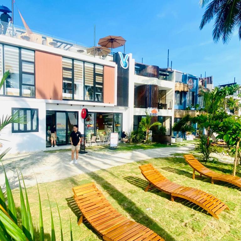 a man standing in front of a building with chairs at V Boutique Hotel Boracay in Boracay