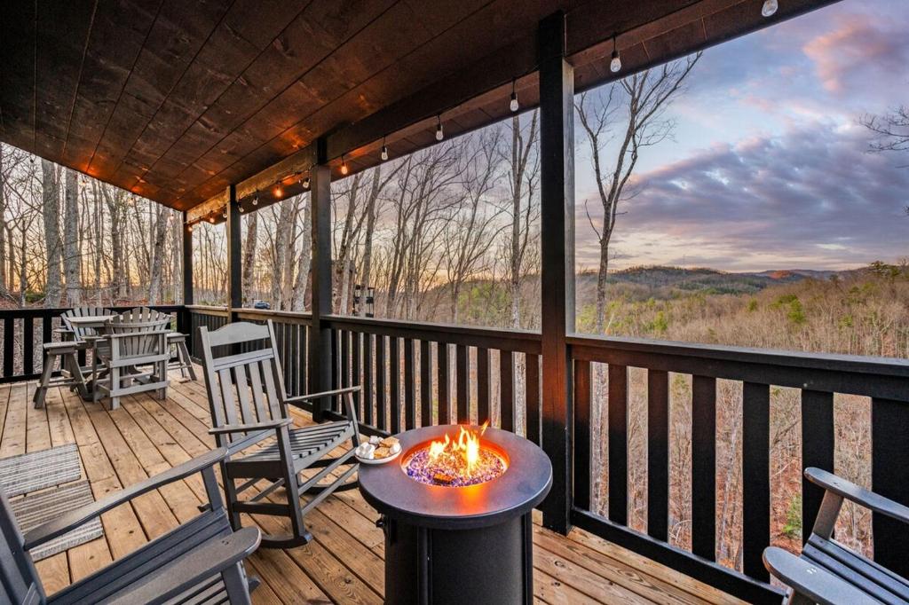 a screened in porch with a fire pit on the deck at Views, Arcade Game, Fire-pit, Hot Tub, Private! in Sevierville