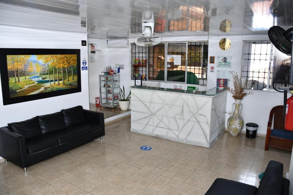 Una sala de estar con un sofá y un televisor en HOTEL BOUTIQUE SONNE BALOP Valledupar, en Valledupar