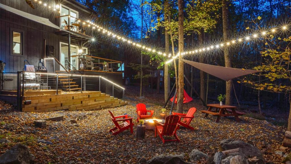 イースト・ストラウズバーグにあるHot Tub Lake Access Community Amenities Somerset Lodge by AvantStayの裏庭(椅子、テーブル、照明付)