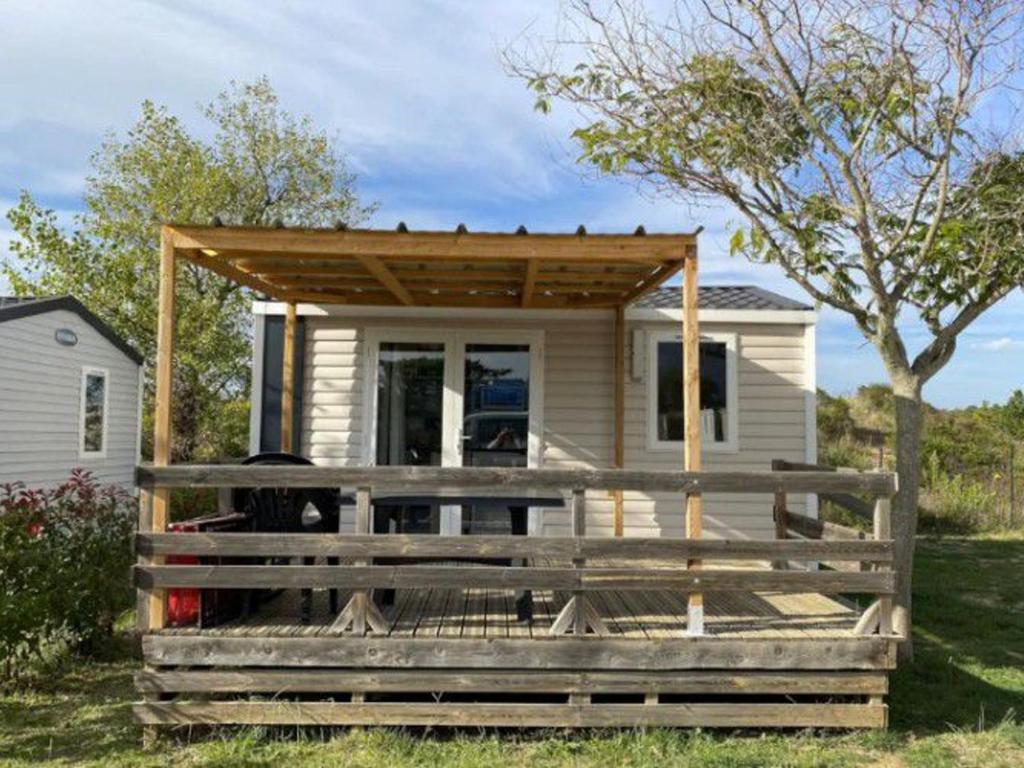 a tiny house with a porch and a deck at Mobil-home avec Terrasse au Camping Mas Llinas - API-1-52-373 in Le Boulou