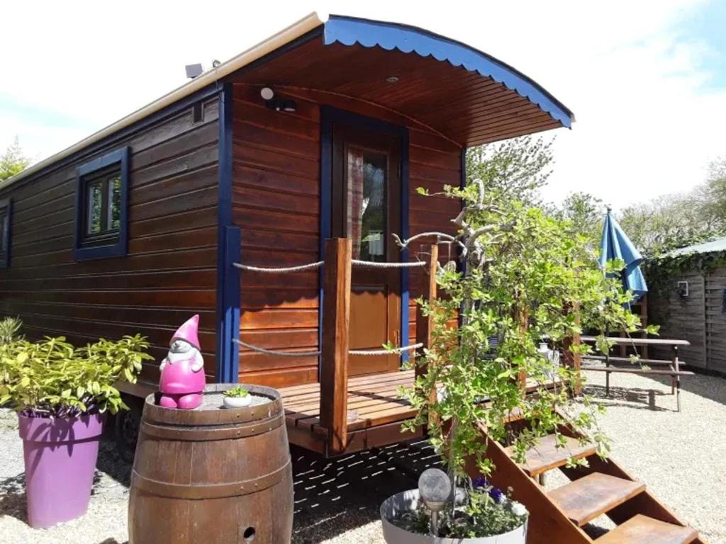 a tiny house with a barrel in front of it at Roulotte Insolite avec Bain Nordique Privé à La Flèche - FR-1-410-485 in Saint-Germain-du-Val